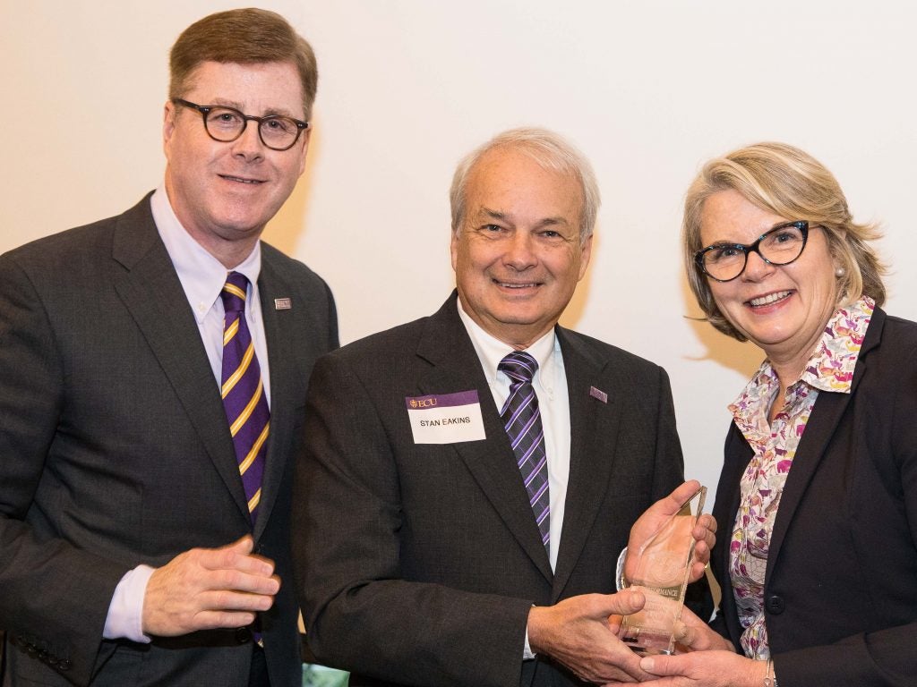 UNC System President Margaret Spellings presented the award to Dr. Stan Eakins, dean of the College, during a reception for UNC Board of Governors members, accompanied by Chancellor Cecil P. Staton, left.