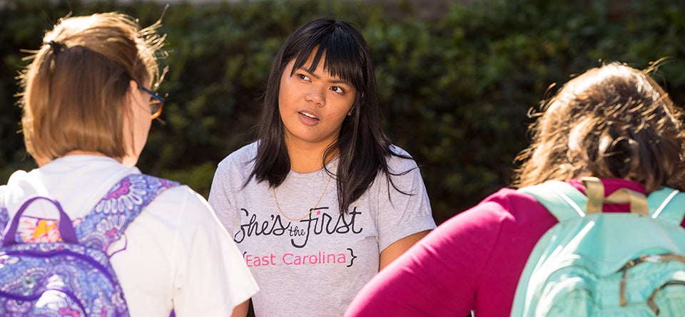 Michelle Anne Reyes, a member of She’s the First, sells cupcakes and talks with students about the Day of the Girl Summit. (Photos by Cliff Hollis)