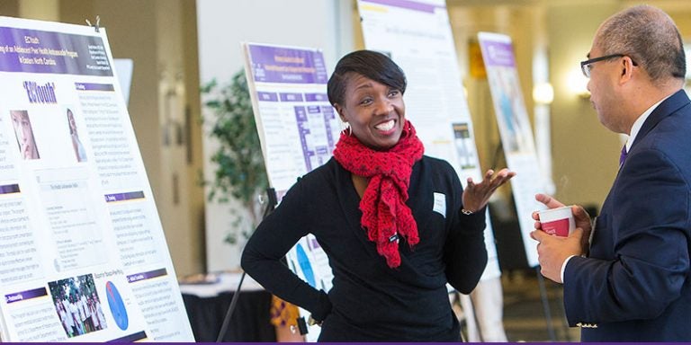 Vashti Kitrell from the Pitt Co. Health Department discusses a display in the lobby of the ECHI with ECU's Xiaoming Zeng during the Mills Symposium. (Photos by Jay Clark)