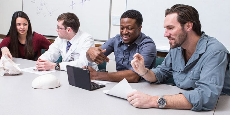 Third-year medical student Kevin Harris (second from left) leads a study session for first-year medical students (from left) Shannon Osborne, Adrian Ambrose and John Hurley. Such leadership is a requirement of students engaged in the Brody School of Medicine’s new Medical Education Distinction Track. (Photo by Cliff Hollis)