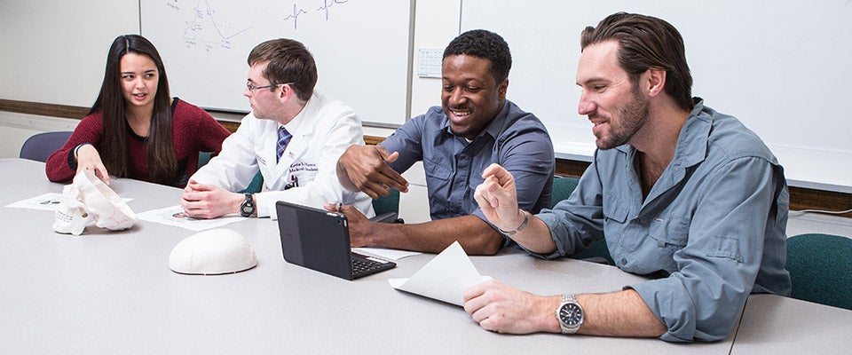 Third-year medical student Kevin Harris (second from left) leads a study session for first-year medical students (from left) Shannon Osborne, Adrian Ambrose and John Hurley. Such leadership is a requirement of students engaged in the Brody School of Medicine’s new Medical Education Distinction Track. (Photo by Cliff Hollis)