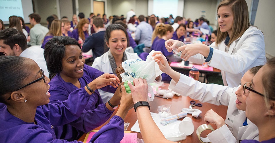 ECU nursing and medical students work together to protect their “patient” – an egg – during an egg drop activity earlier this semester meant to teach collaboration and quality improvement. (Photos by Cliff Hollis)