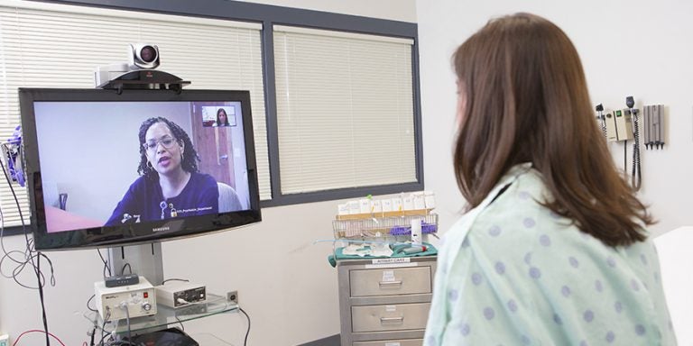 With the use of telepsychiatry, Brody School of Medicine psychiatrists like Dr. Toni Johnson (on screen) can connect with patients in hospital emergency departments statewide. (Photos by Cliff Hollis)