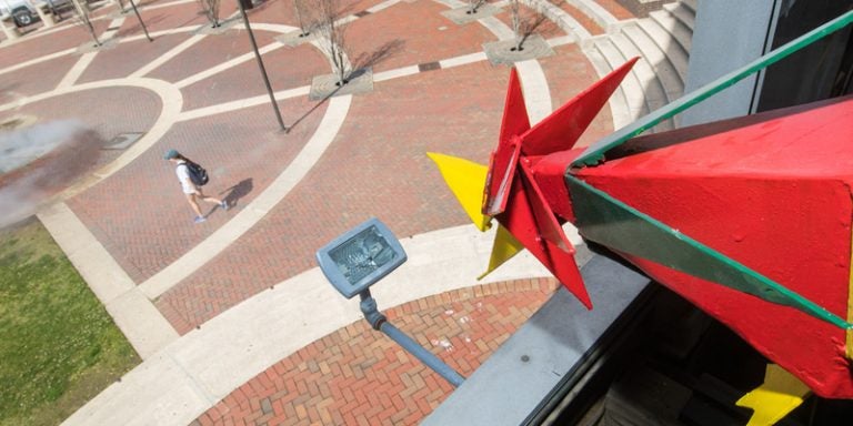 A brightly colored cuckoo emerges from the Sonic clock tower during a test run of the installation in the plaza next to Joyner Library. (Photos by Cliff Hollis)