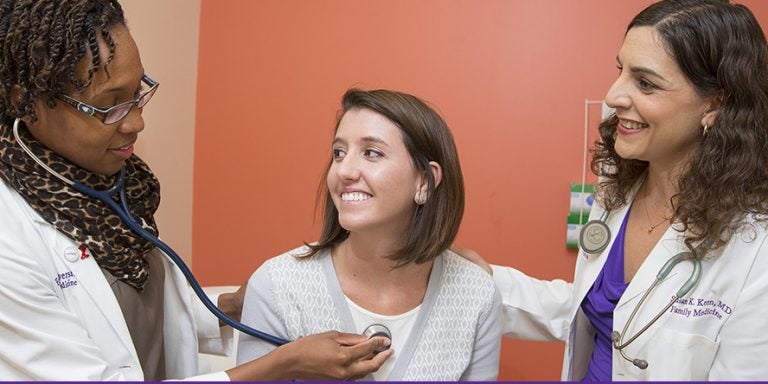 ECU family medicine practitioner Dr. Susan Keen, right, and medical student Demetria Watford, left, collaborate on a patient exam. ECU's graduates in primary care medicine stick with that field at a rate higher than other state medical schools, according to a recent report. (Photos by Jay Clark)