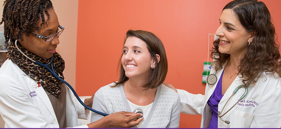 ECU family medicine practitioner Dr. Susan Keen, right, and medical student Demetria Watford, left, collaborate on a patient exam. ECU's graduates in primary care medicine stick with that field at a rate higher than other state medical schools, according to a recent report. (Photos by Jay Clark)