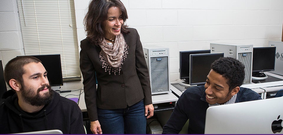 Associate professor Rosana Ferreira, center, from ECU's Department of Geography, Planning and Environment, works with graduate student Mark Nissenbaum, left, and undergraduate Joel McAuliffe. A grant from the ECU Faculty Senate enabled Ferreira to create a virtual weather forecasting teaching laboratory (Photos by Cliff Hollis)