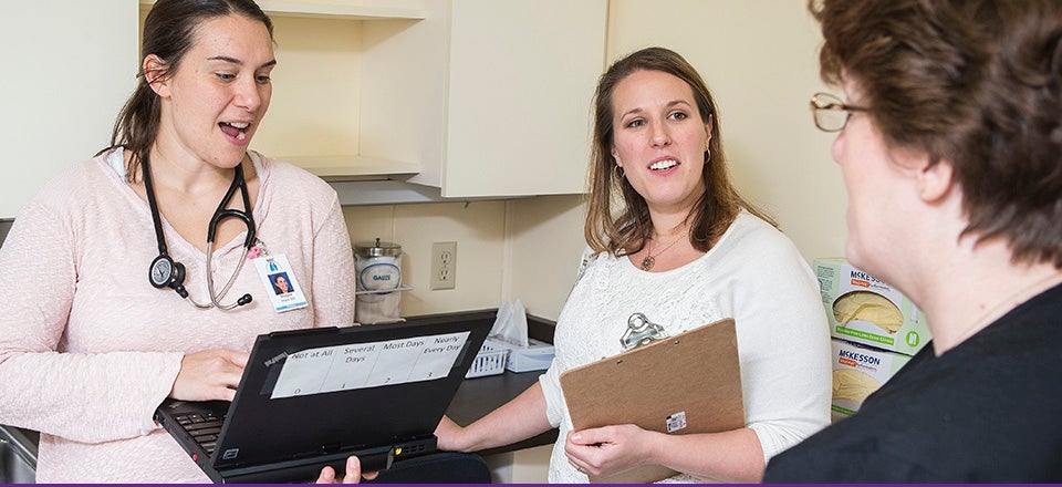 Dr. Modjulie Moore, left, and Julie Austen collaborate to assist a patient. Austen is among the 2014 graduates of the Health Psychology doctoral degree with a concentration in pediatric school psychology. (Photo by Cliff Hollis)