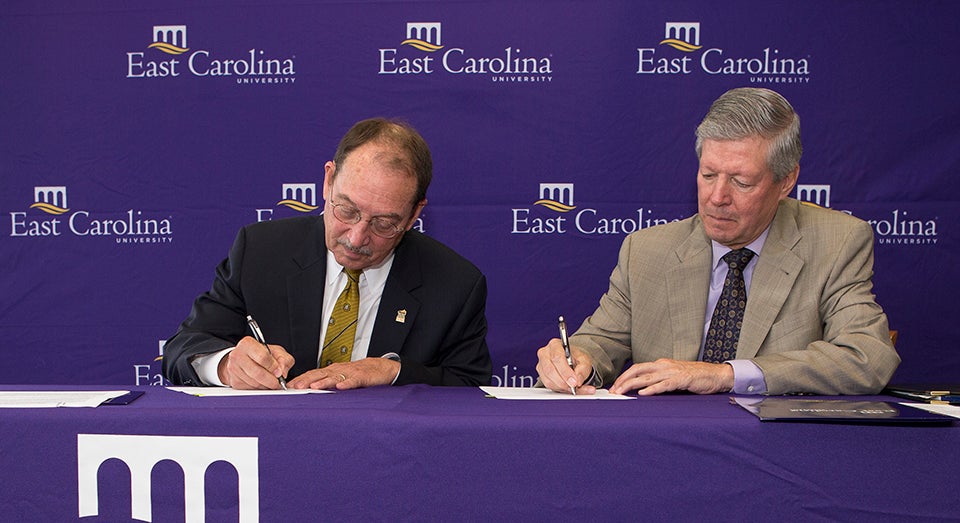 UNC Pembroke Chancellor Kyle Carter and East Carolina University Chancellor Steve Ballard sign a memorandum of understanding that will establish a satellite program for ECU's doctorate in physical therapy at UNCP. The agreement aims to prepare more physical therapists for eastern North Carolina. (Photos by Cliff Hollis)