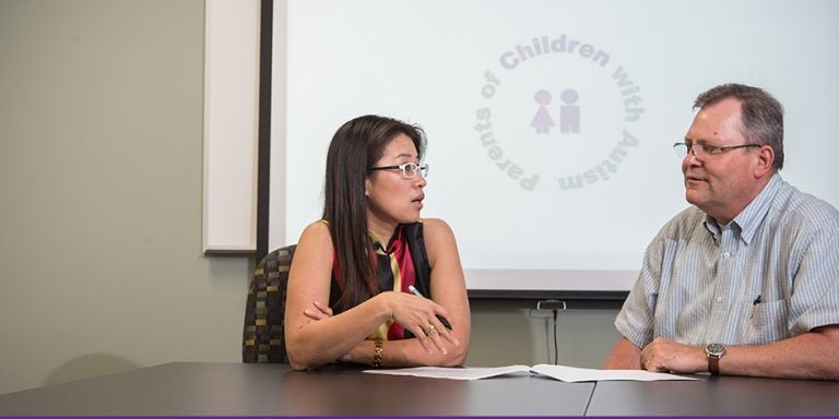 Health Education and Promotion professor Dr. Lei Xu, left, speaks with pharmacology professor Dr. Ken Soderstrom. Soderstrom has participated in Xu's research on genetic testing with parents of children with autism. (Photo by Cliff Hollis)