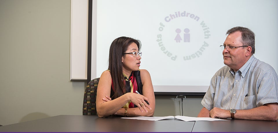 Health Education and Promotion professor Dr. Lei Xu, left, speaks with pharmacology professor Dr. Ken Soderstrom. Soderstrom has participated in Xu's research on genetic testing with parents of children with autism. (Photo by Cliff Hollis)