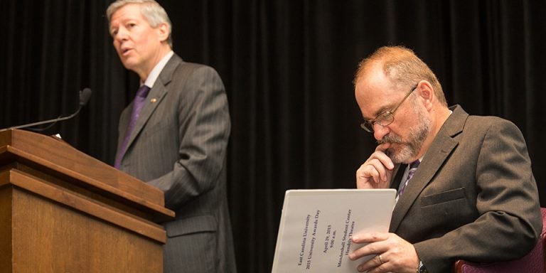 ECU Chancellor Steve Ballard speaks during the university's awards day ceremonies, while Provost Ron Mitchelson studies the order of events. (Photos by Cliff Hollis)