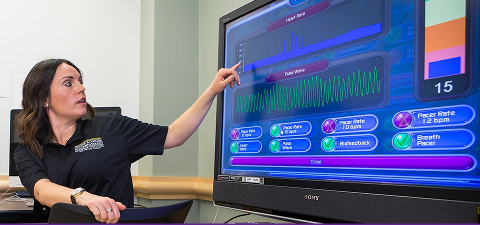 ECU doctoral student Christina Brown-Bochicchio shares details on how biofeedback can help wounded warriors during the March 20 opening of ECU's Center for Applied Psychophysiology. (Photos by Cliff Hollis)