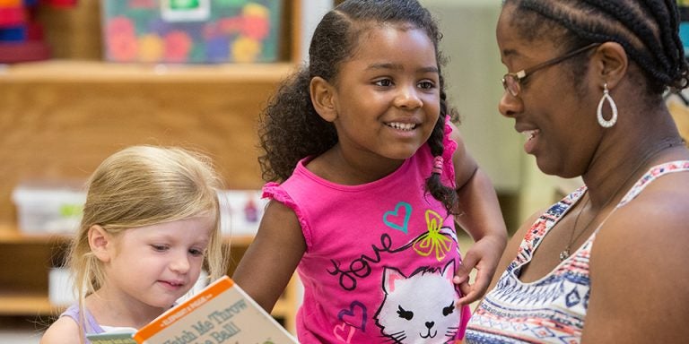 The Nancy Darden Child Development Center provides child care while offering hands-on experiences for ECU students seeking to learn about early childhood development and education. Pictured above, left to right, preschoolers Sutton Norris and Marai Blanchard enjoy reading time with Breania Best, a teacher assistant in the preschool classroom. (Photos by Cliff Hollis)