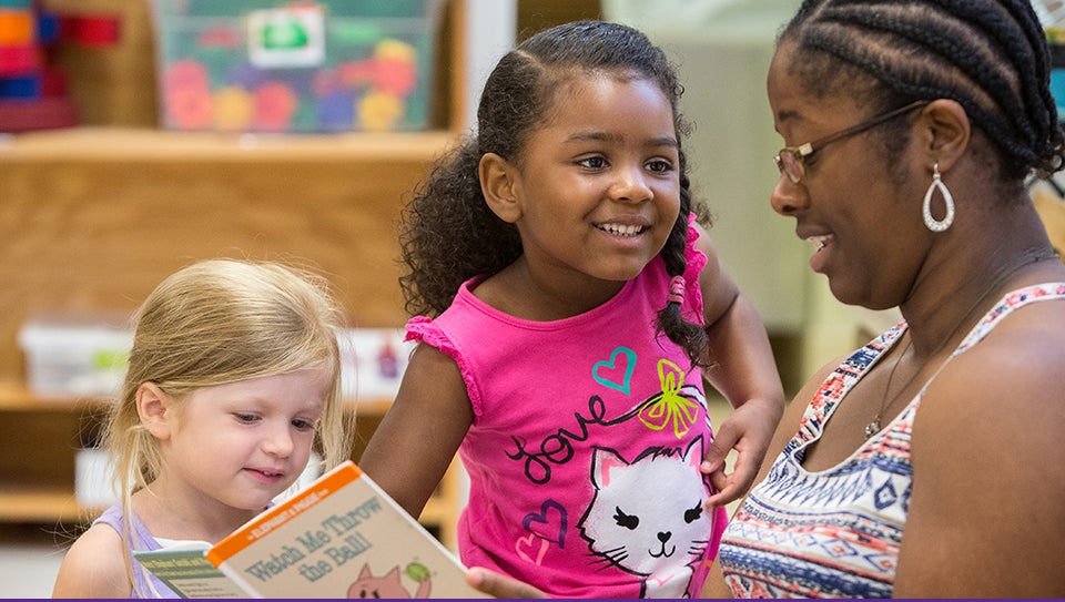 The Nancy Darden Child Development Center provides child care while offering hands-on experiences for ECU students seeking to learn about early childhood development and education. Pictured above, left to right, preschoolers Sutton Norris and Marai Blanchard enjoy reading time with Breania Best, a teacher assistant in the preschool classroom. (Photos by Cliff Hollis)