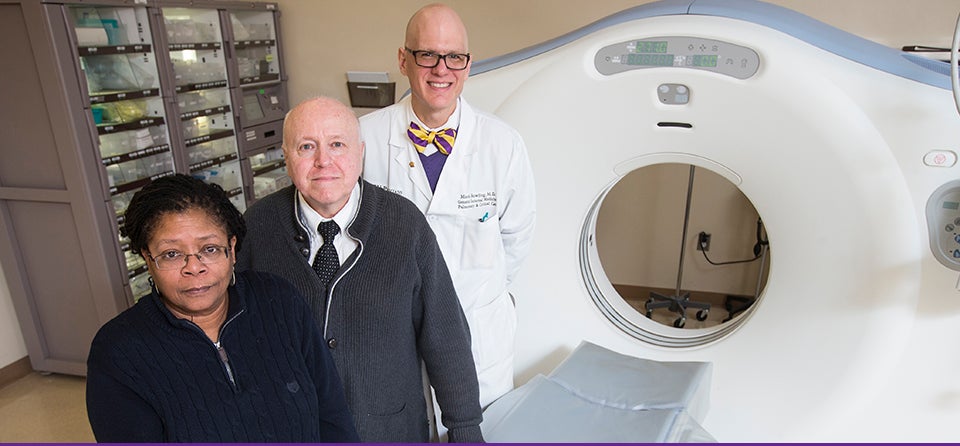 ECU researchers are examining why African-American patients with lung cancer tend to present at a more advanced stage than their Caucasian counterparts. Pictured above, left to right, are Dr. Hope Landrine, director of the Center for Health Disparities; the study's lead author Dr. Jimmy Efird, assistant director for the Center for Health Disparities; and Dr. Mark Bowling, director of interventional pulmonology for ECU. They are shown at Vidant Medical Center with a CT scanner that can screen patients for early evidence of lung cancer. (Photo by Cliff Hollis)