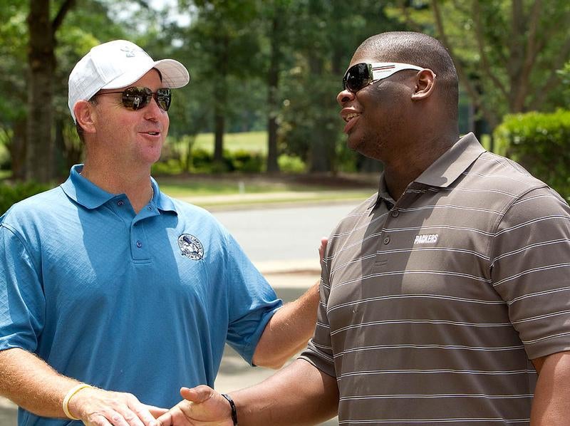 Former head football coach Skip Holtz, left, and former player C.J. Wilson, now in the NFL, talk at the tournament. Photo by Cliff Hollis, ECU News Services.