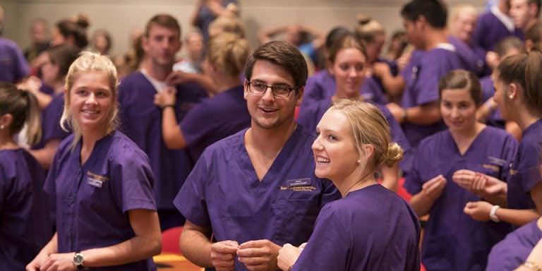 First year nursing students, left to right, Cara Benedue, Kevin Beasley and Lauren Baker prepare for pinning each other at the Lamp of Learning ceremony held on campus on Thursday (Photos by Gretchen Baugh)