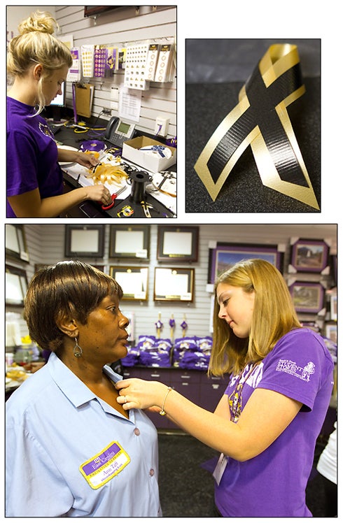 CHRIS MURPHY REMEMBERED: Employees at the Dowdy Student Store at East Carolina University handed out ribbons July 11 in memory of ECU employee Chris Murphy, who was killed in an weekend accident. Murphy was assistant director at ECU's Office of Undergraduate Admissions. Pictured above, Hillary Bunch pins a ribbon for Ann Taft in Housekeeping, who knew Murphy from working in the same building. In the upper left, Jeannette Williams prepares ribbons for distribution. (Photos by Cliff Hollis)