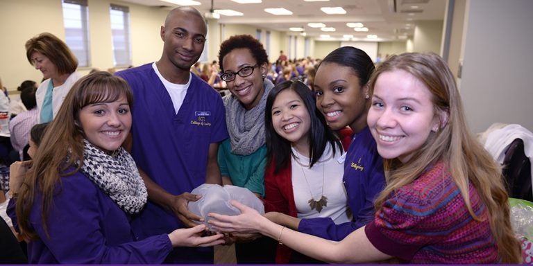 First-year medical students and third-semester nursing students from ECU's Quality Improvement Olympics hold their protected raw egg that will be dropped from a stepladder. The protection was created during a timed teamwork exercise. Team members, from left, are Skyler Cauley, Isaiah Dunnaville, Jennifer Okpala, Dan-Thanh Nguyen, Staci Allgood, Sam Olsen. (Photos by Gretchen Baugh)