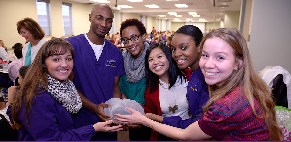 First-year medical students and third-semester nursing students from ECU's Quality Improvement Olympics hold their protected raw egg that will be dropped from a stepladder. The protection was created during a timed teamwork exercise. Team members, from left, are Skyler Cauley, Isaiah Dunnaville, Jennifer Okpala, Dan-Thanh Nguyen, Staci Allgood, Sam Olsen. (Photos by Gretchen Baugh)