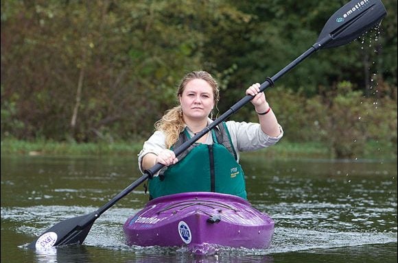 ECU student Kimberly Chadwick steers a kayak down the Tar River in Greenville. Chadwick had worked through ECU service-learning connections to develop a kayaking educational tour in the community. (Photo by Cliff Hollis)