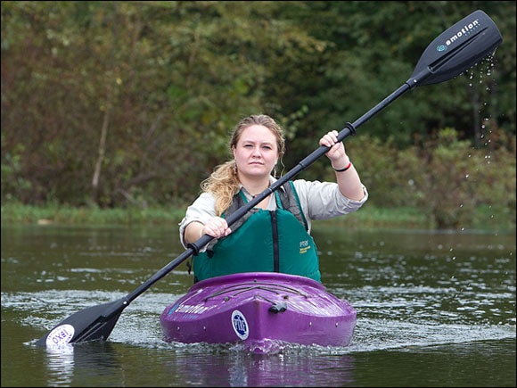 ECU student Kimberly Chadwick steers a kayak down the Tar River in Greenville. Chadwick had worked through ECU service-learning connections to develop a kayaking educational tour in the community. (Photo by Cliff Hollis)