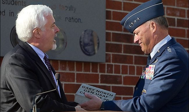 Images from the East Carolina University Veterans Day celebration include placing a brick paver in honor of Gen. Gary L. North, an ECU alumnus and four-star general who attended the celebration; Cpt. Justin Hochstein surrounded by bayonets during the drill team performance; Army vet John Hart with a pirate marine cap he calls his 