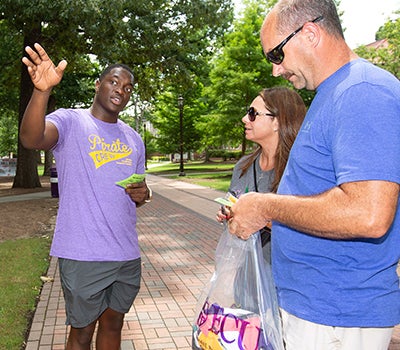 ECU student Davarion David gives directions to the West End Dining Hall to a family during new-student orientation Thursday.