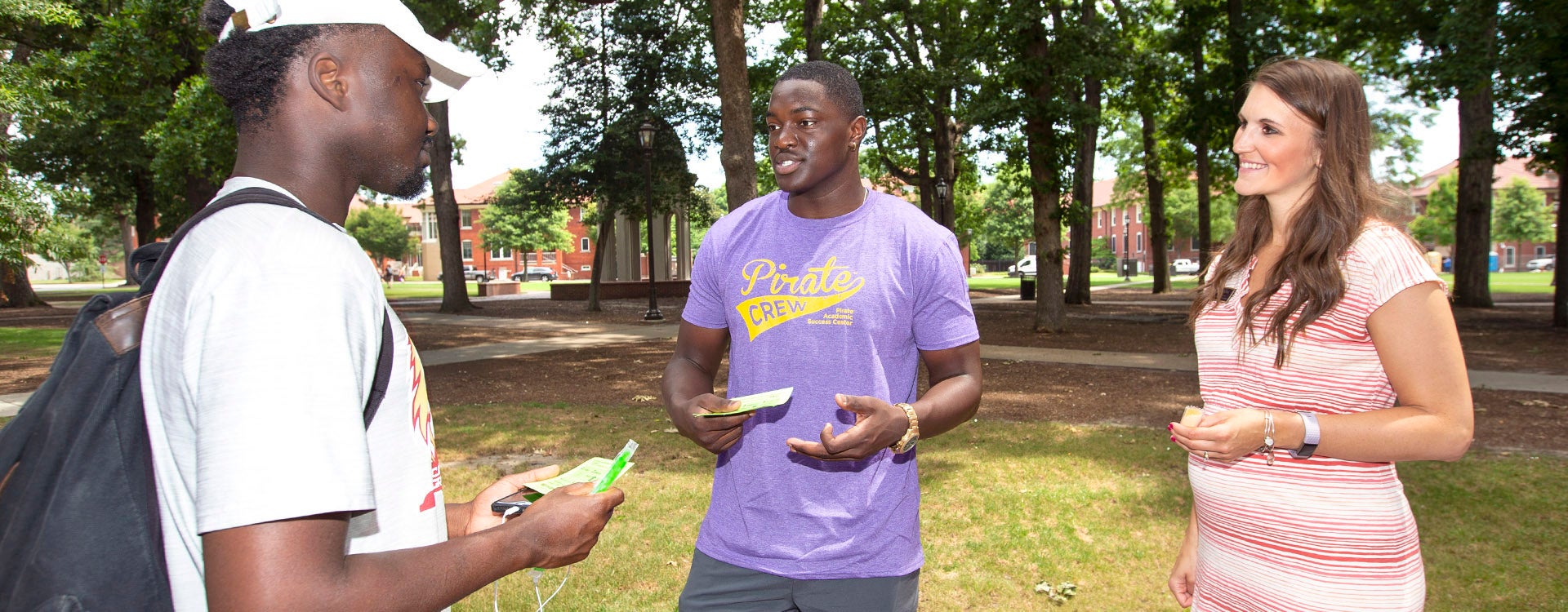 Davarion David, center, and Brittany Hoyt, assistant director at the Pirate Academic Success Center, talk to a summer school student about what the center has to offer while passing out popsicles on the mall Thursday. (Photos by Rhett Butler)