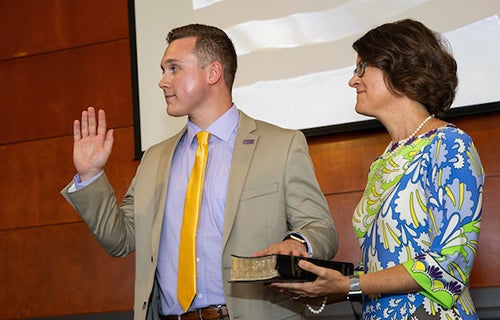 Student Government Association president Jordan Koonts, accompanied by his mother, Sarah Koonts of Apex, is sworn in as an ex-officio member of the ECU Board of Trustees.