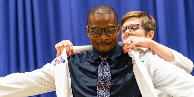 Kenneth Lowery II receives his coat during the Brody School of Medicine White Coat Ceremony for the Class of 2022. (Photo by Cliff Hollis)