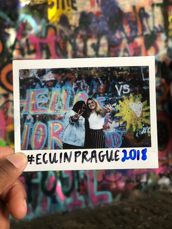 ECU students Briana McRae and Amanda Curran visit the John Lennon Wall in Prague.