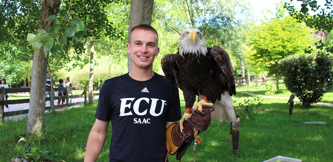Austin Allen holds a bald eagle while touring a local zoo outside of a small town in Spain. 