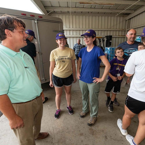 Beulaville Mayor Hutch Jones talks with ECU medical students Amber Whitmill, left, and Anna Laughman at Pathway Church in Beulaville, N.C. (Photo by Cliff Hollis)
