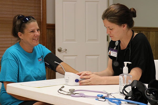 Maggie Blakemore, right, a student in ECU’s Doctor of Nursing Practice program, works with a patient in Varnamtown during a GWEP screening event. (Photo by Matt Smith)