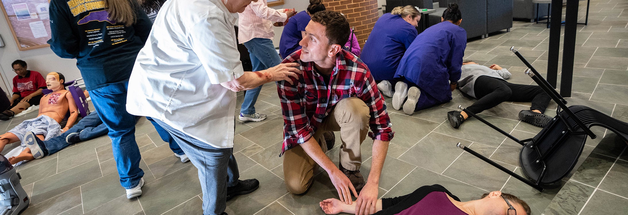 Brody School of Medicine student Dylan Flood pauses to speak to a victim while assessing another during the interprofessional mass casualty simulation at the College of Nursing on Nov. 10. (Photos by Cliff Hollis)