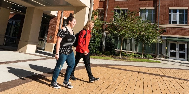 Residential Scholars Samantha Willard and Brandon Fellenstein walk together on ECU’s campus. (Photo by Cliff Hollis)