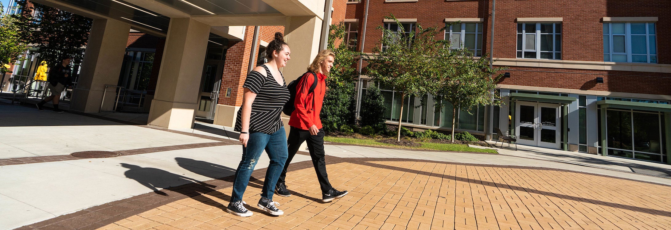 Residential Scholars Samantha Willard and Brandon Fellenstein walk together on ECU’s campus. (Photo by Cliff Hollis)