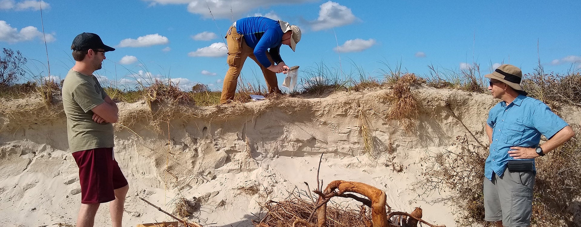 Graduate student Cody Allen (center) collects samples along the shoreline at Hammocks Beach State Park. Allen is working on Mallinson’s team to investigate how the coastline has changed after Hurricane Florence. Also pictured are ECU student Taylor Miller (left) and Dr. Steve Culver (right).