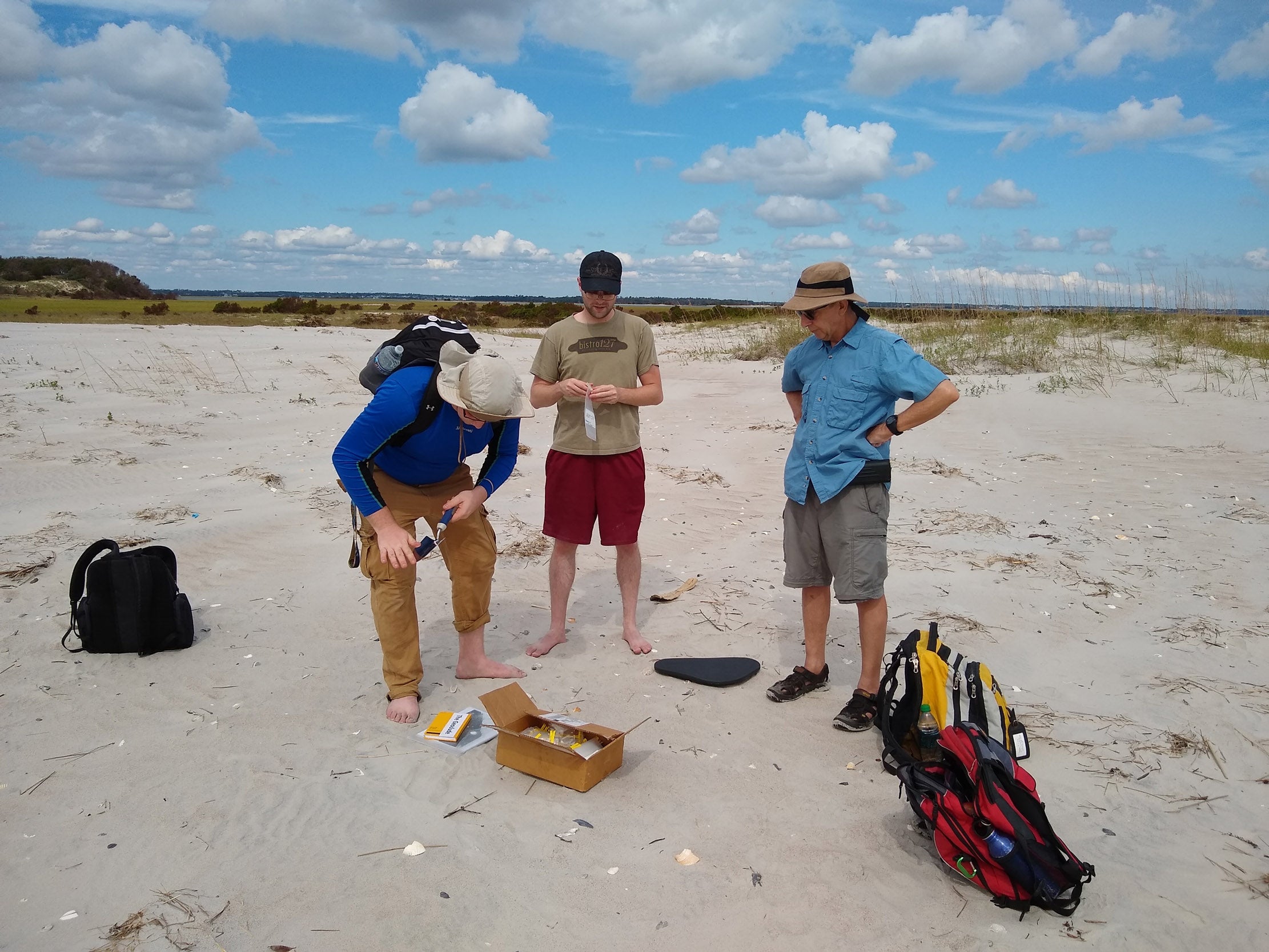 Graduate student Cody Allen (left) collects sediment samples at Hammocks Beach State Park for Mallinson’s RAPID research project. ECU student Taylor Miller and Dr. Steve Culver assist.