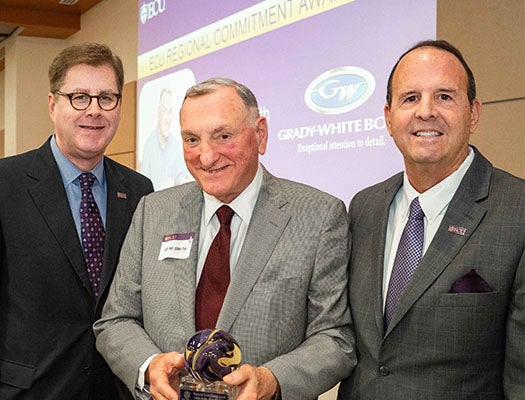 Grady-White Boats owner and CEO Eddie Smith (center) is presented with ECU’s Regional Commitment Award by Chancellor Cecil Staton (left) and Vice Chancellor for Research, Economic Development and Engagement Jay Golden.
