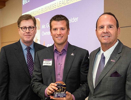 Grover Gaming owner and CEO Garrett Blackwelder is presented with ECU’s Emerging Business Leader Award by Chancellor Cecil Staton (left) and Vice Chancellor for Research, Economic Development and Engagement Jay Golden.