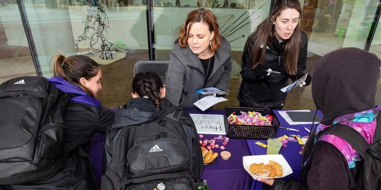 Associate Dean of Students Lauren Thorn, left, and Carter Morsell, donor relations coordinator for the Division of Student Affairs Office of Development, talks to students at the Pirate Nation Gives table outside of the Main Campus Student Center on Wednesday.