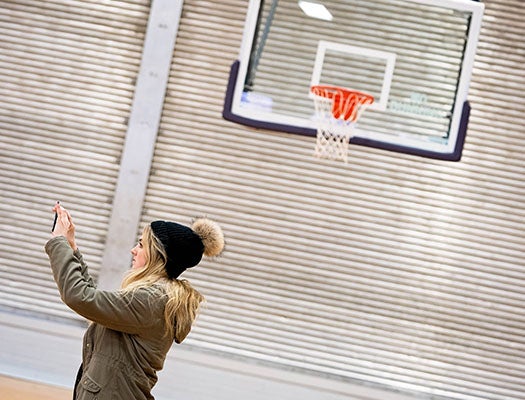 An interior design student photographs Christenbury Gym.