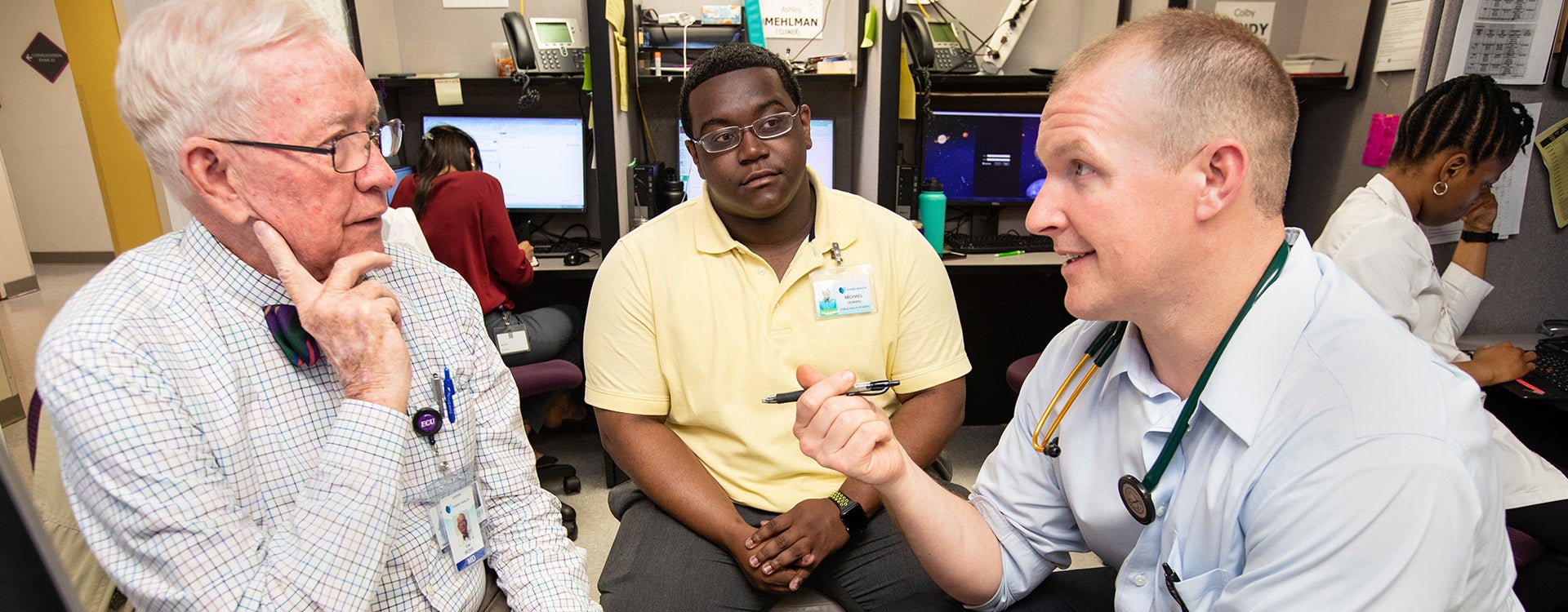 ECU graduate Michael Denning, center, learns about working with children at ECU Physicians Pediatric Outpatient Center. 