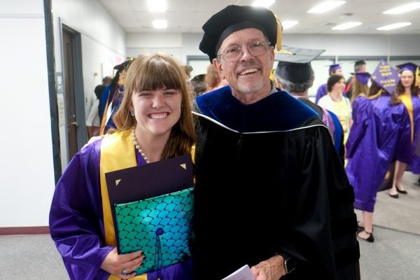 Dr. Kirkland poses for a photo with a student during the English commencement in 2019.