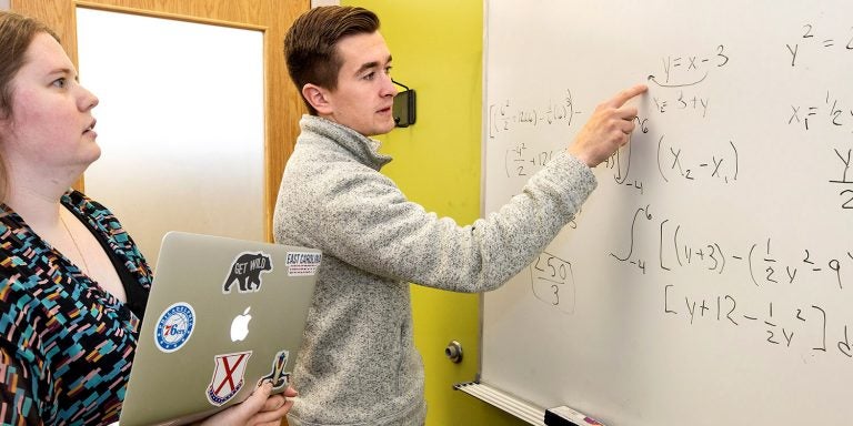 Amber Arnold, assistant director of student success in the Pirate Academic Success Center, works with ECU student Nolan McDonald on an assignment. Photo by Rhett Butler.