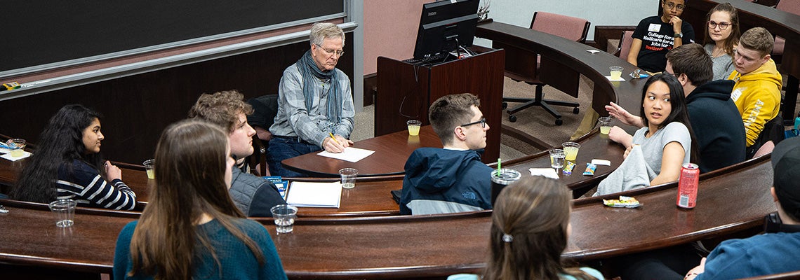 Rick Steves jots down questions from students in the Bate Building. Photo by Cliff Hollis