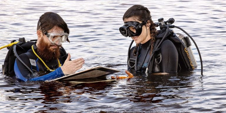 Graduate students Patrick Boyle, left, and Andi Yoxsimer document their research during investigation of the shipwreck in Washington, N.C. (Photo by Rhett Butler)
